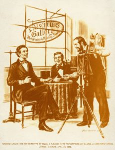 Drawing by Ostendorf, 1975, of President Abraham Lincoln with Samuel G. Alschuler in Alschuler's photography gallery. The sign reads, "S. Alschuler's Gallery, Photographic & Printing Studio." The image is captioned, "Abraham Lincoln sits for ambrotype by Samuel BG. Alschuler in the photographer's coat as Judge J.O. Cunningham watches, Urbana, Illinois, April 25, 1858."