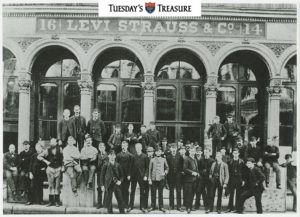 Black and white photograph of workers posed in front of the Levi Strauss and Co. factory building. 