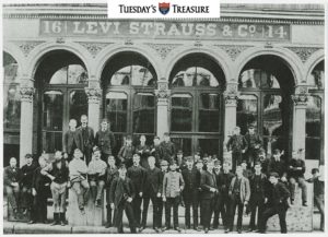 Black and white photograph of workers posed in front of the Levi Strauss and Co. factory building.