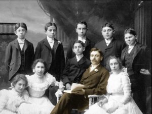 Black and white image of Rabbi Franklin sitting with young students.